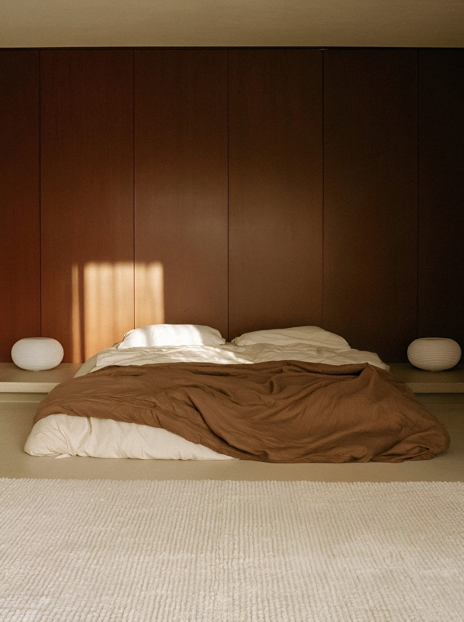 Bed with brown linen in minimalist room.