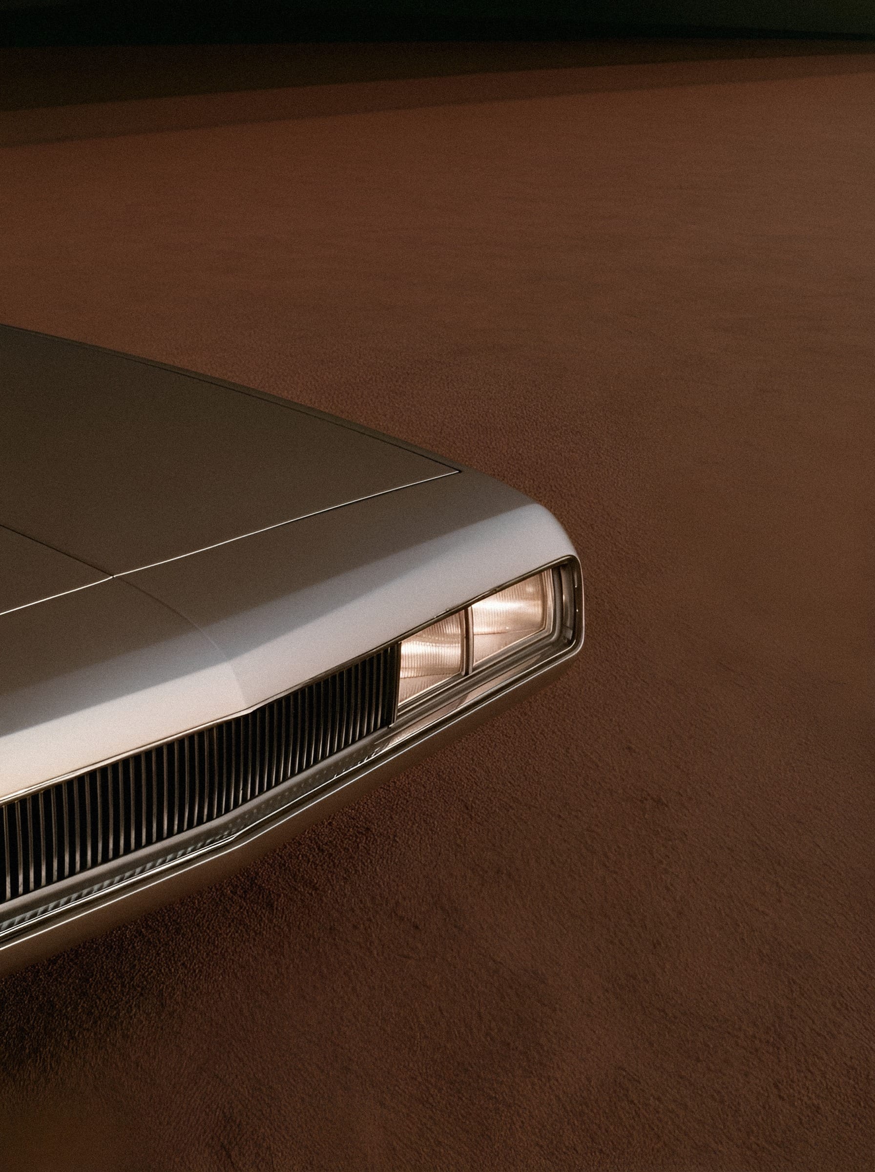 A rectangular car lamp and narrow chrome grille against cream bodywork.