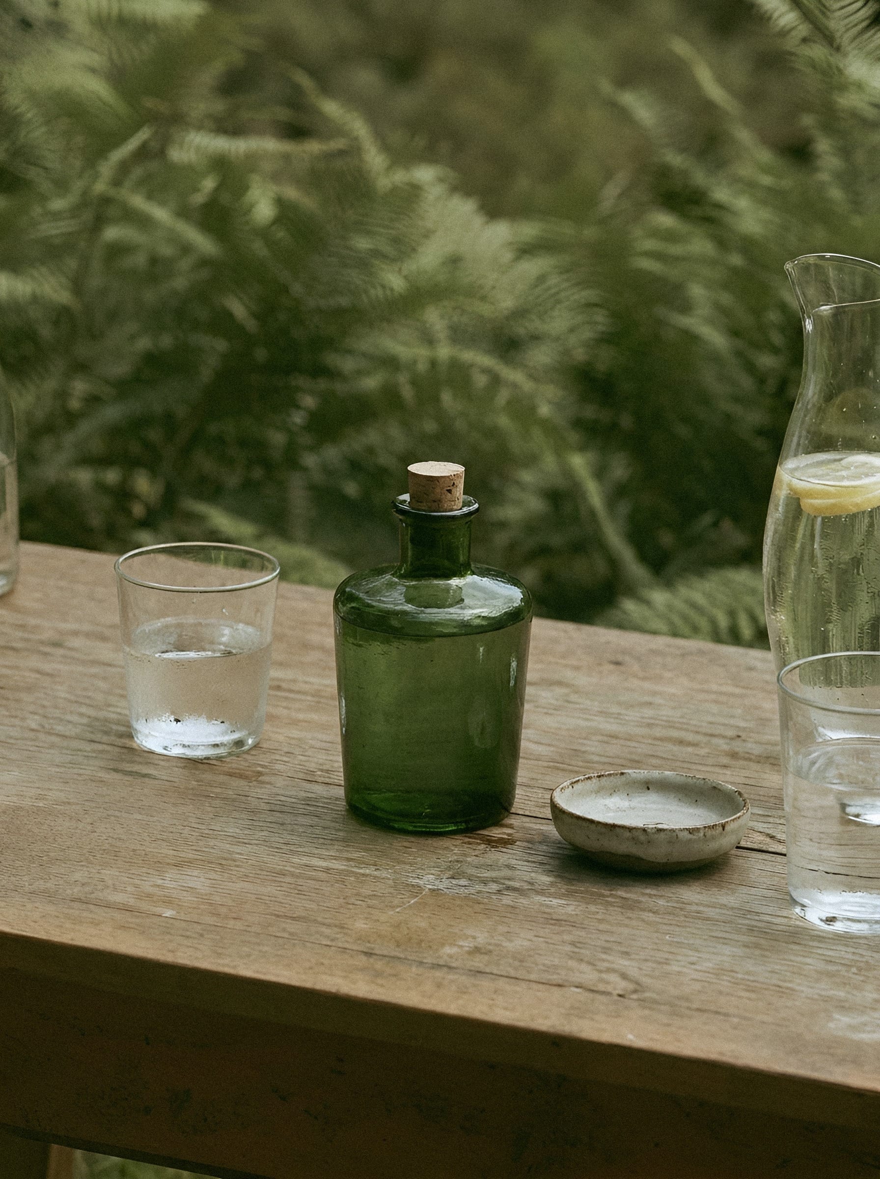 Green glass bottle on wooden surface.