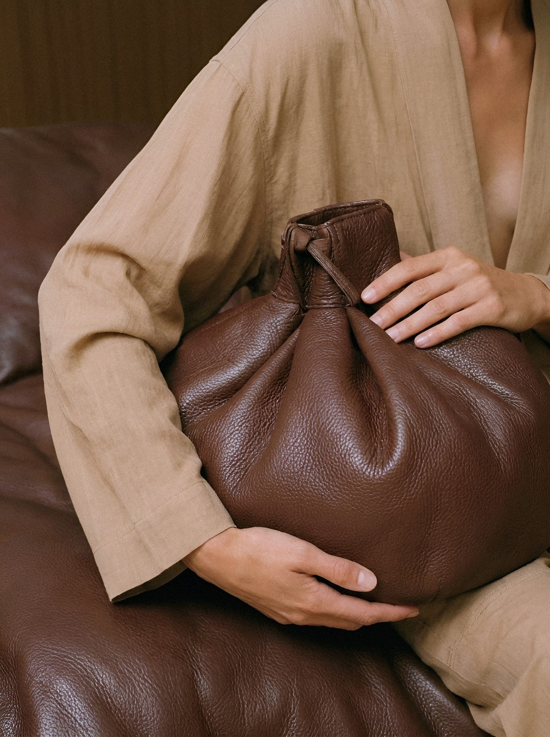 Hands holding leather pouch.
