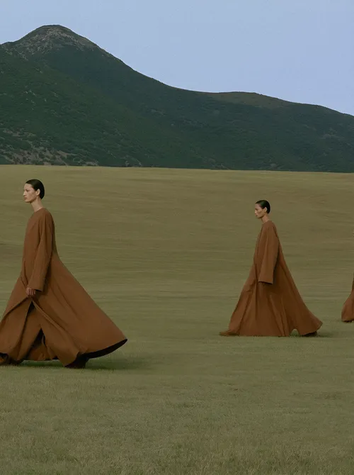 Figures in camel cloth crossing plain.