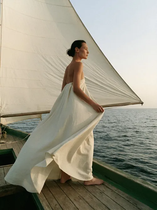 Woman in linen on wooden deck.