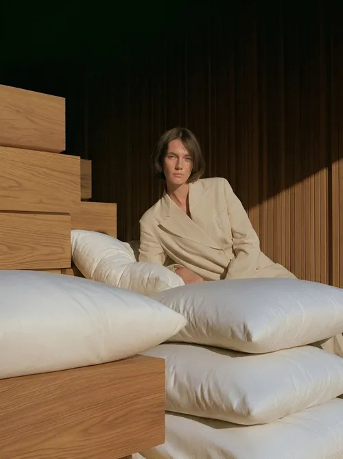 Woman with stacked pillows and wood.
